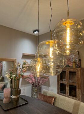 drie hanglampen met ronde vormen en gouden fitting