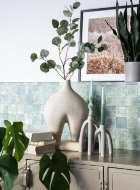 Groene Dinerkaarsen Op Kast Beige Kandelaren En Beige Vaas Met Eucalyptustak