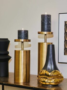 Gouden kaarsenhouders met zwarte stompkaarsen