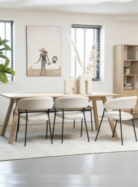 Witte bouclé eetkamerstoelen met zwarte poten aan houten eettafel