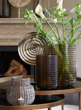 Antiek Bronzen Rond Ornament Op Zwarte Voet Bronzen Salontafelset Met Zwart Blad Bruine Glazen Vazen Met Ribbel Motief En Witte Bos Bloemen