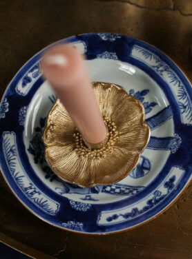 Gouden Bloemen Kandelaarhouder Op Een Delfsblauw Bordje En Een Roze Kaars