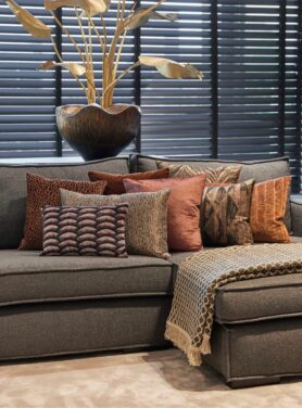 Taupe beige claudi plaid op grijze bank