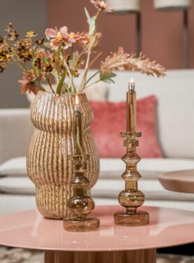 Bruine gestreepte vaas bruine glazen kandelaren op roze metalen salontafel
