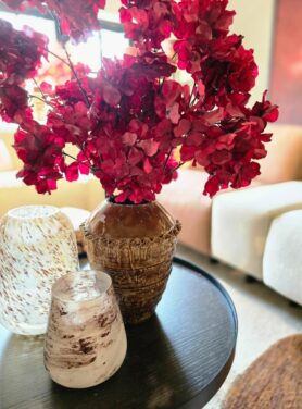 Bruine hoge vaas met geribbelde rand en rode kunsttakken