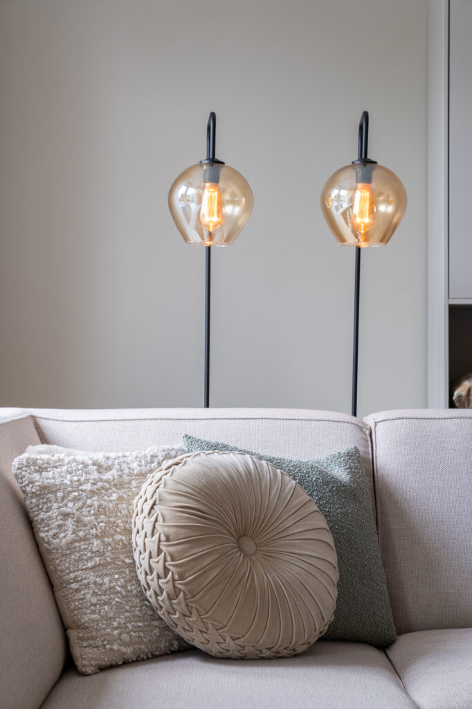 lichte bank met licht beige kussens en lichtblauw met chique lampen